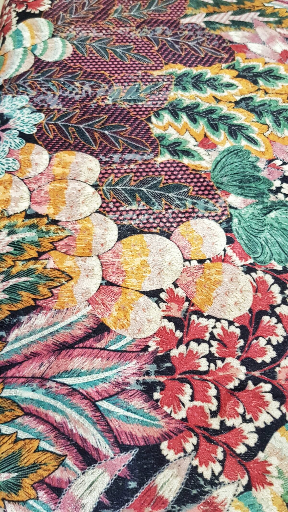 Banqueta tapizada vintage con estampado floral y patas negras con dorado.